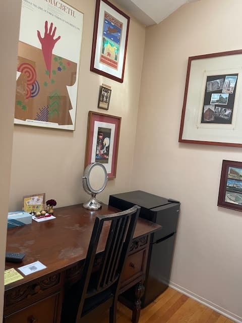 wooden desk & chairs with floor lamp, brown wall and white wall