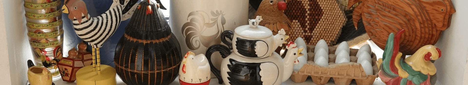A collection of decorative chicken-themed items and pottery displayed together.