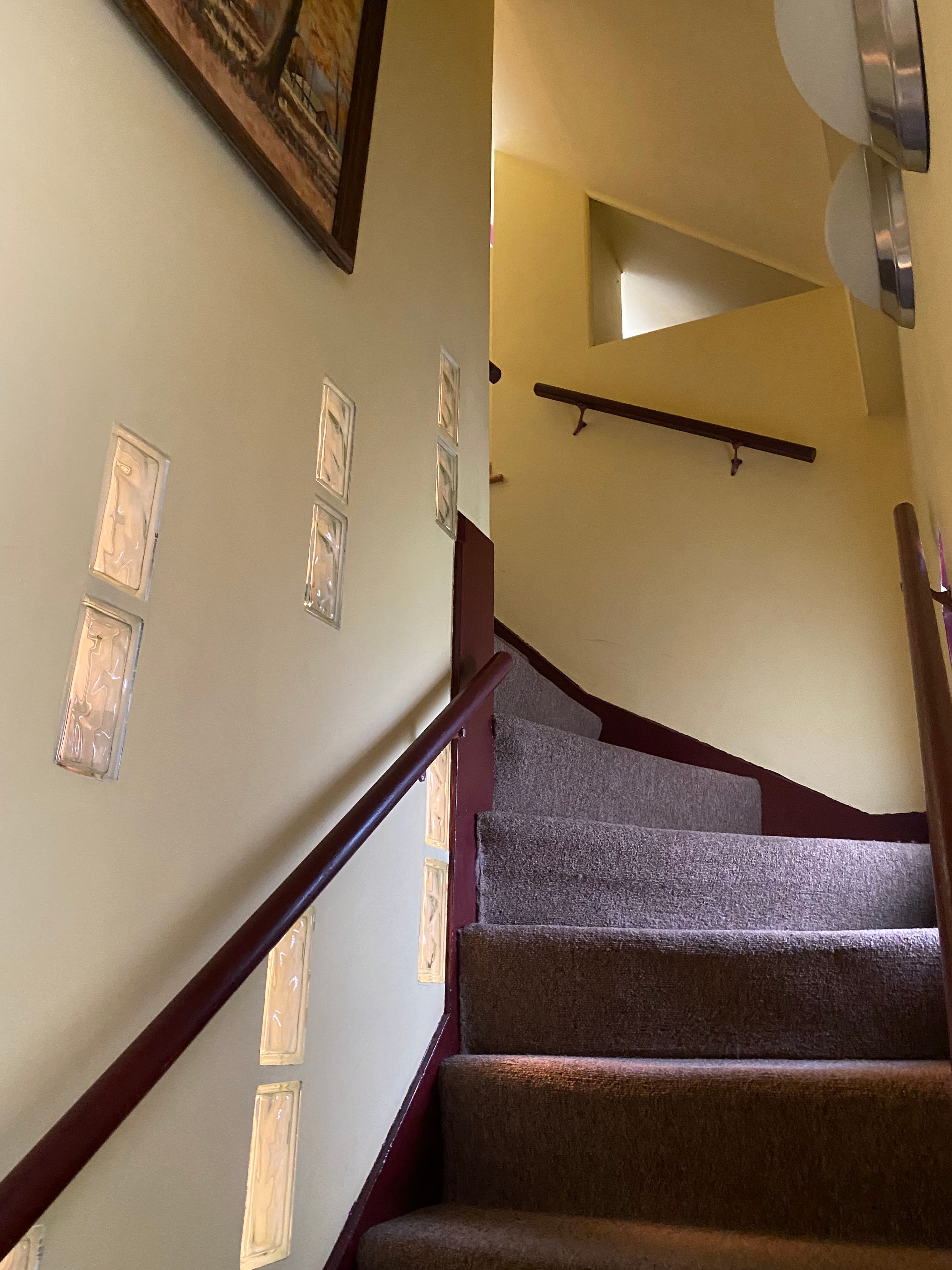 Stairs leading to an upper level, lined with decorative panels on the wall.